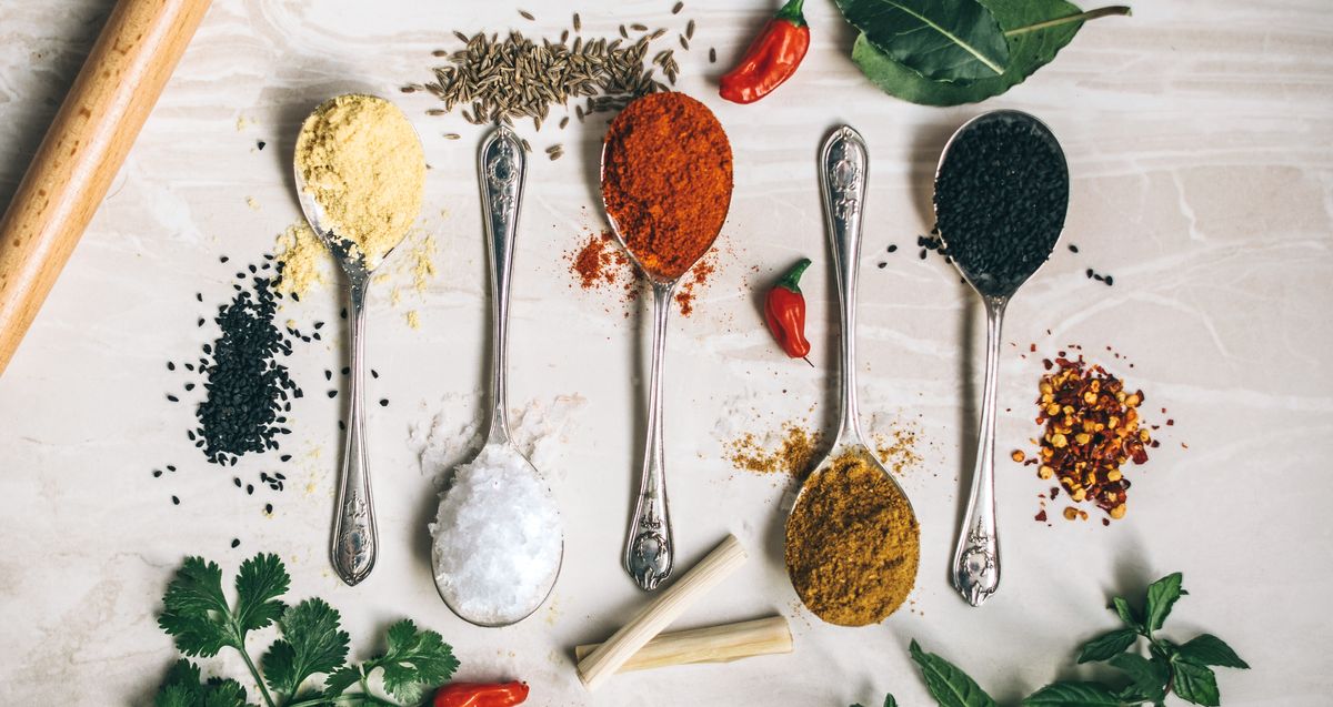 Five herbs with different colours arranged on five spoons
