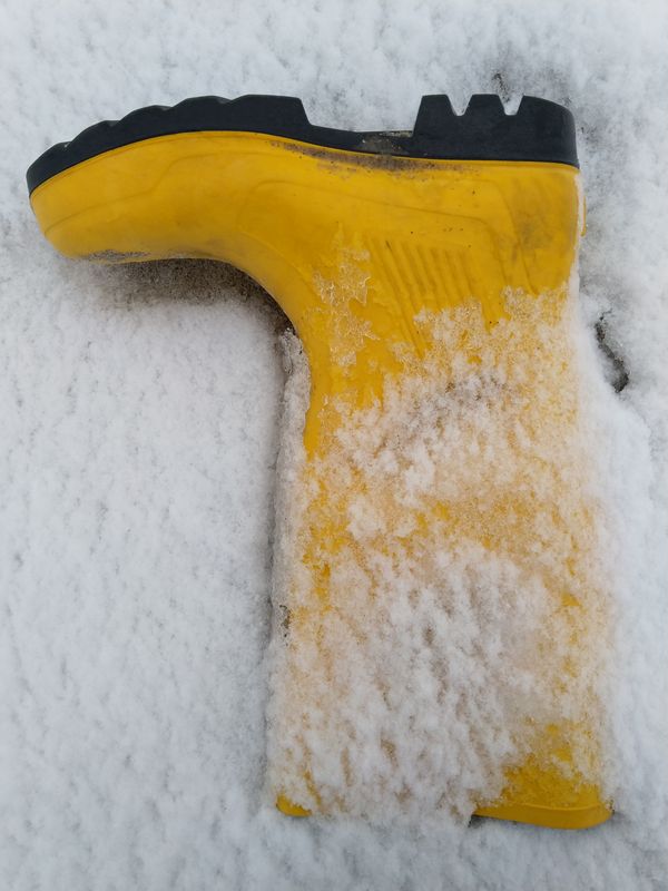 gelber Gummistiefel im Schnee auf dem Kopf